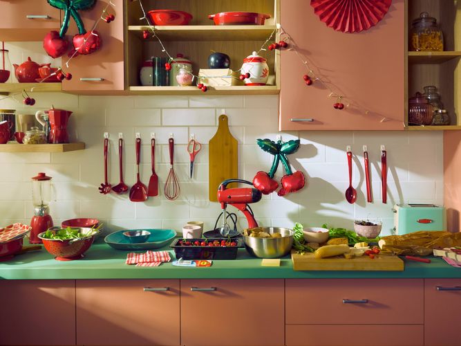 3M Command Hooks used to organise kitchen utensils, decorations and oven mitts on a tiled splashback above a kitchen benchtop.