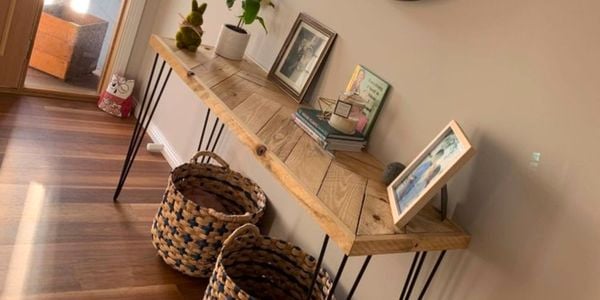 A timber hallway table with a mirror and storage baskets