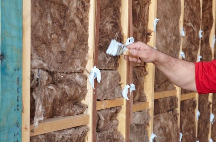 Stud adhesive being applied to wall studs by a Bunnings team member