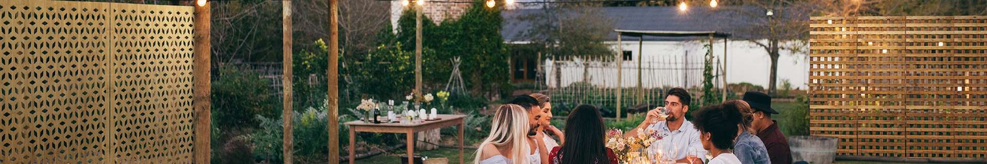 Group of people having a candlelit dinner in a garden