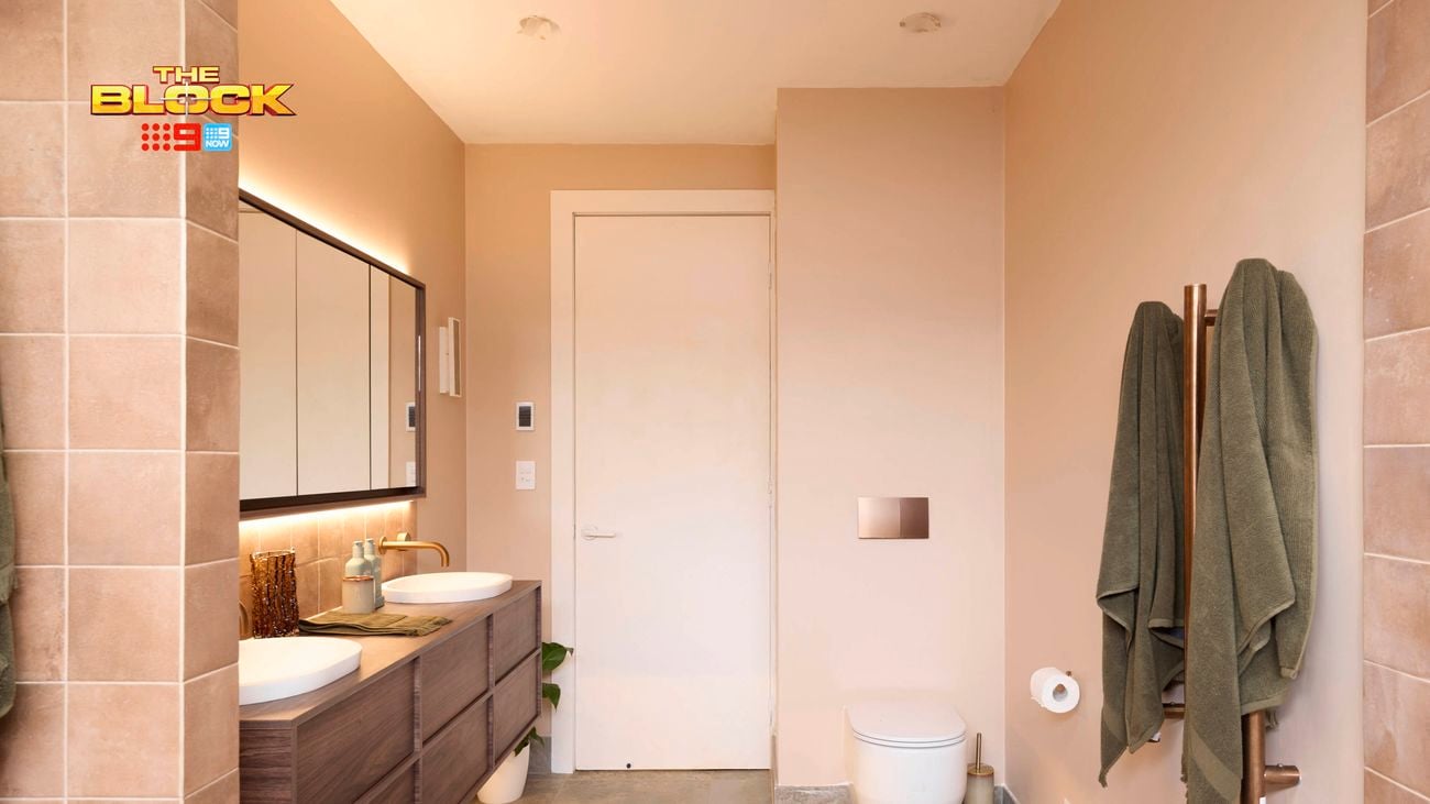 Natural coloured brown bathroom with timber vanity with towel rails and toilet