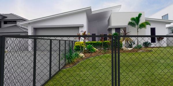 Black wire grid fence at the front of a house
