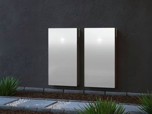 Modern house with Tesla car parked in the driveway and a tesla powerwall on the side of the house