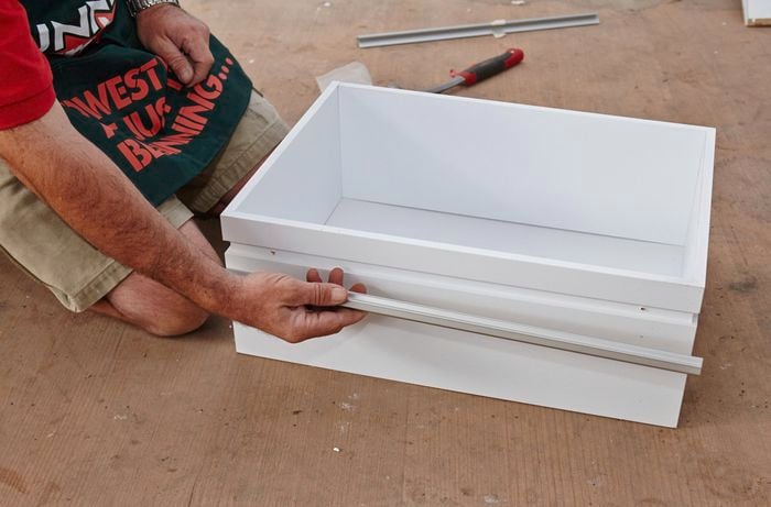 Person putting draw runners in place.