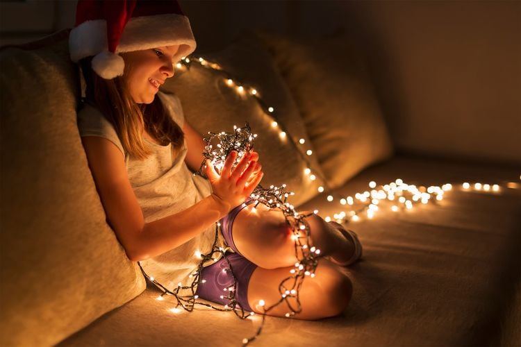 Girl sitting on couch with rolled up fairy lights