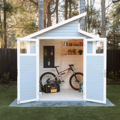 Contemporary light blue storage shed with asymmetrical skillion roof and wide-opening doors, displaying a bicycle, tools, and shelving inside.