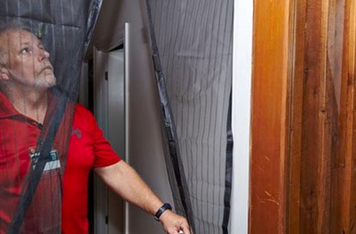 A Bunnings team member opening a magnetic flyscreen