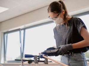 Person using Dremel sanding tool on timber