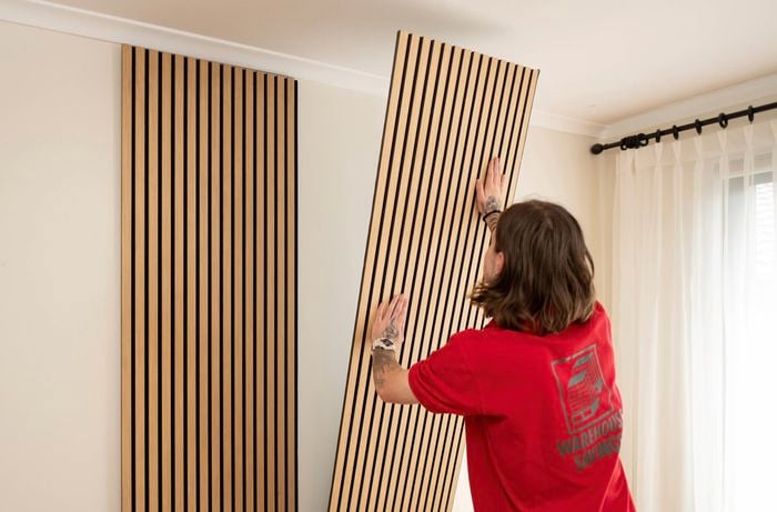 Aligning and pressing panels for solid adhesive contact with the wall.