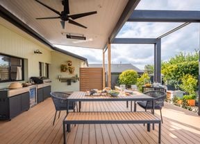 Outdoor entertaining area with an outdoor table, chairs, BBQ and a ceiling fan