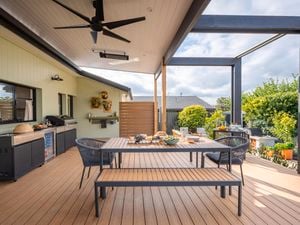 Outdoor entertaining area with an outdoor table, chairs, BBQ and a ceiling fan