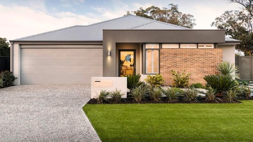 A house with a driveway and plants and a front yard lawn.