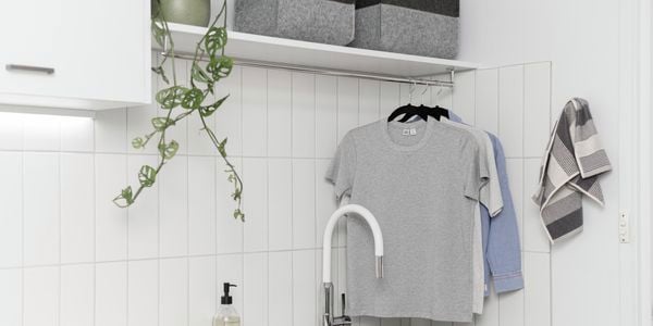 Laundry bench with tiled wall and hanging cloths