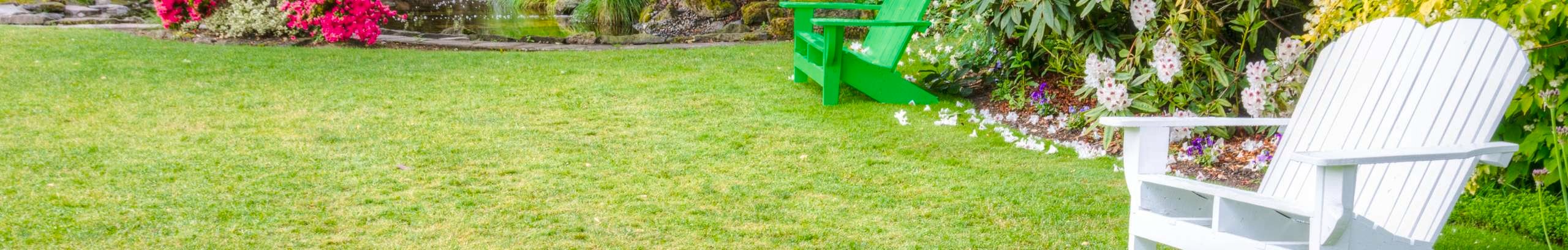 A green lawn with wooden garden seats