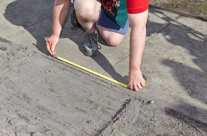 A Bunnings team member measuring and marking out the position of a brick letterbox