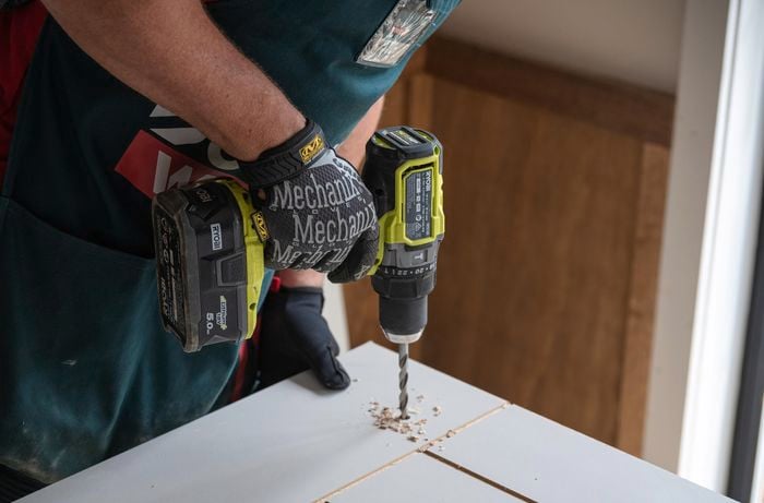 Team member drilling a hole in a door.