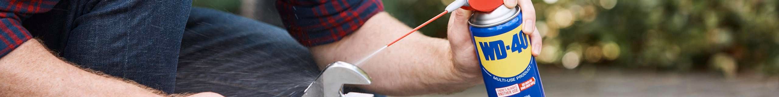 man cleaning his tools with a multi-use product from wd-40