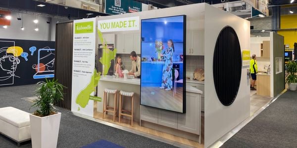Wide view of the Kaboodle Kitchen exhibition stand at the Auckland Home Show, featuring kitchen displays, digital screens and branded signage.