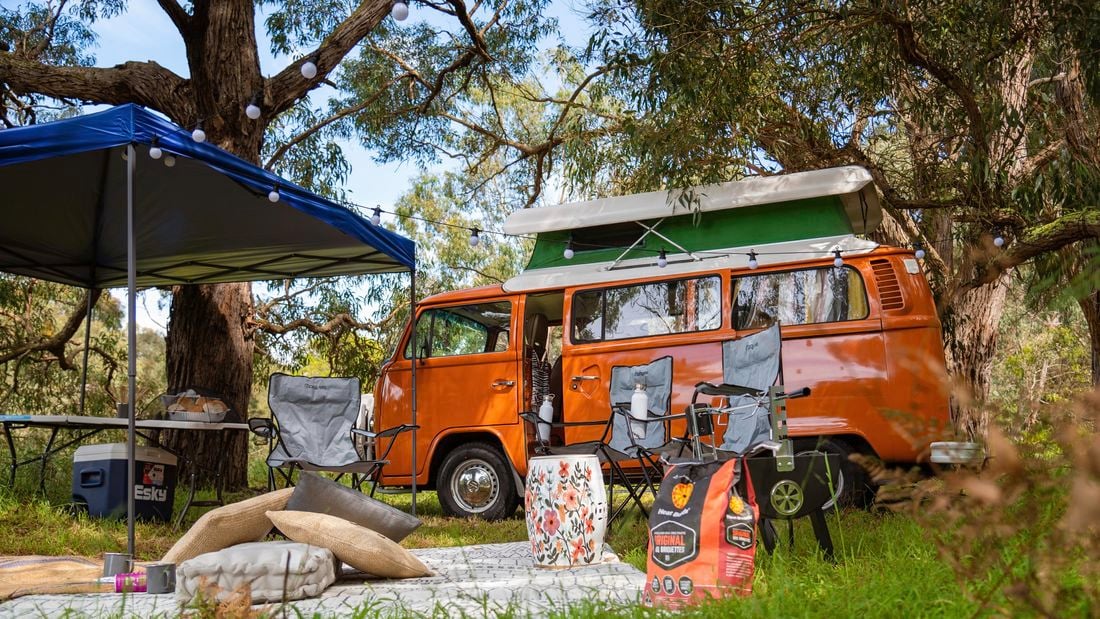 Orange combi, gazebo, camping chairs and table.