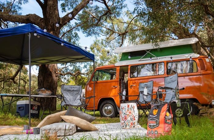 Orange combi, gazebo, camping chairs and table.