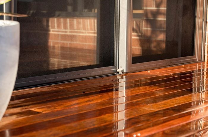 Decking outside a house with a plant