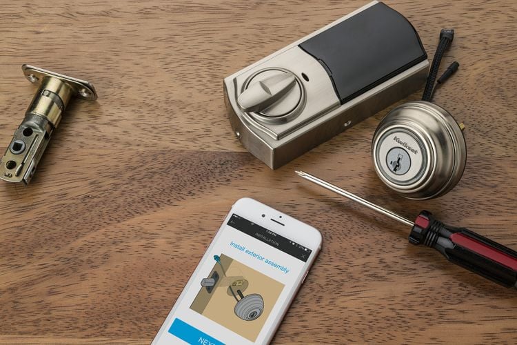 Pieces of door lock with assembly manual displayed on a phone