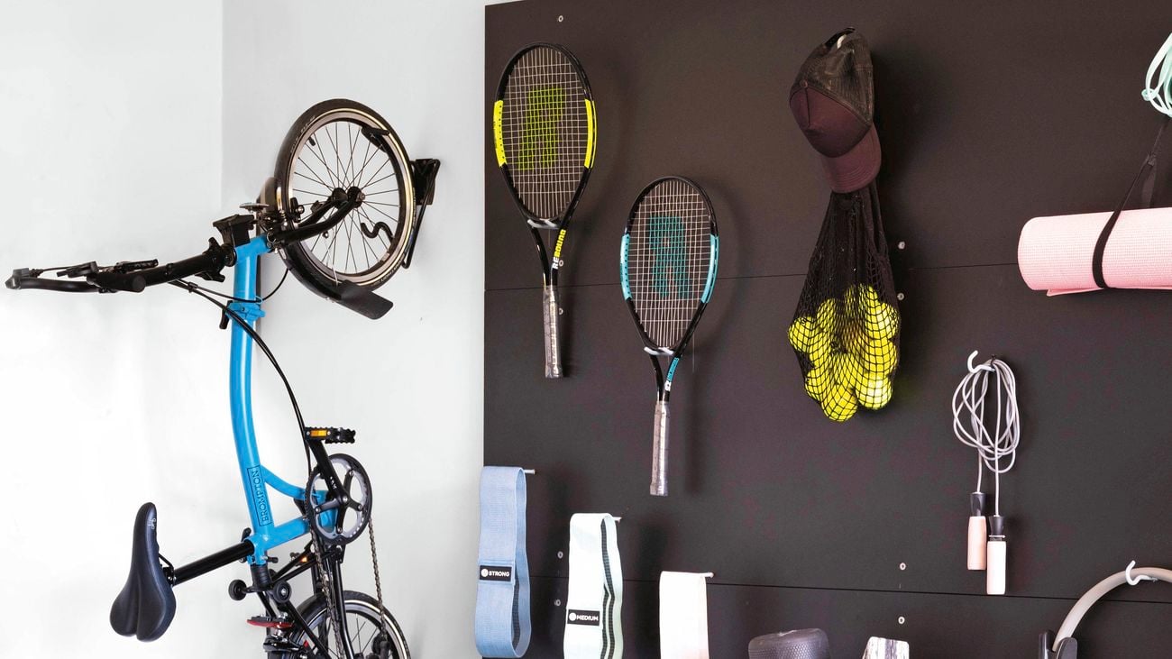 Bike and sporting equipment attached to wall in garage.