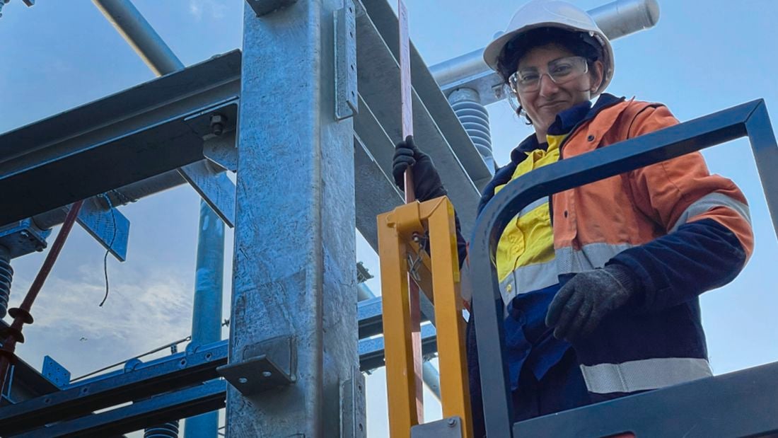 Women in construction advocate Faiza Nazar, a female electrical apprentice, dressed in hi vis workwear and full PPE