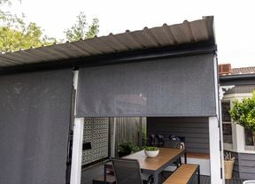 Halfway opened outdoor roller blind.