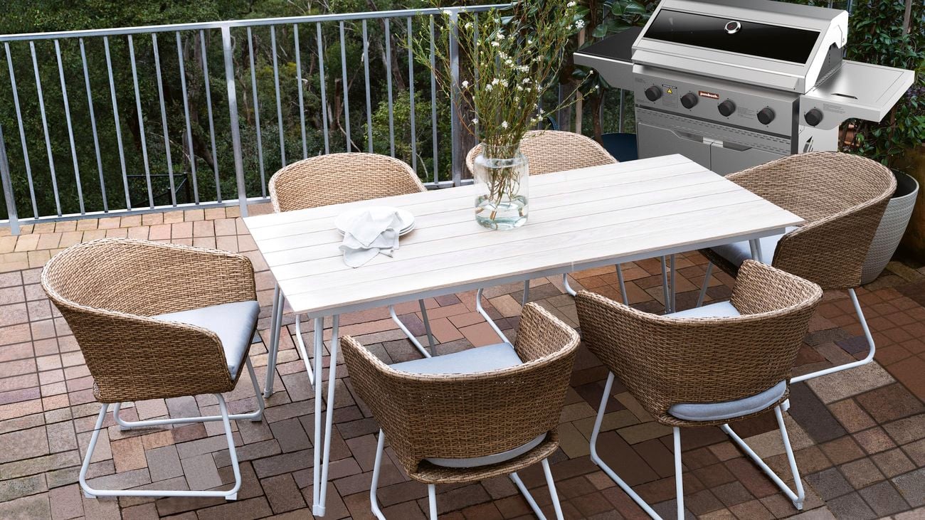 Silver barbecue on a patio featuring an outdoor dining table
