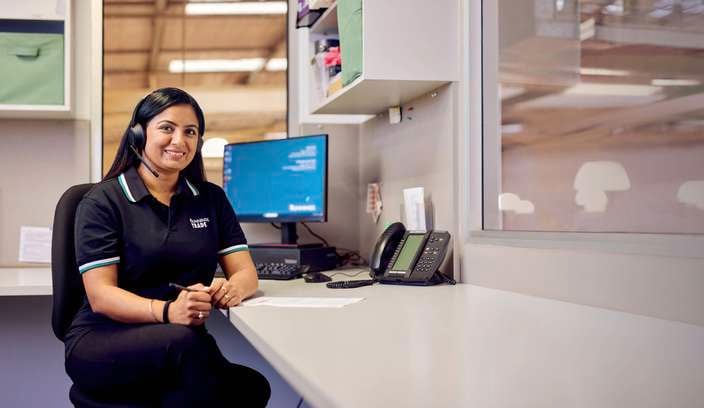 Lady sitting at an office desk with head peice on