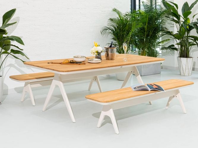 An outdoor dining setting with teak benches and table