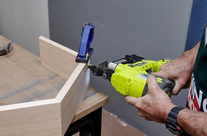 A hexagonal shelf frame being nailed together with a nail gun