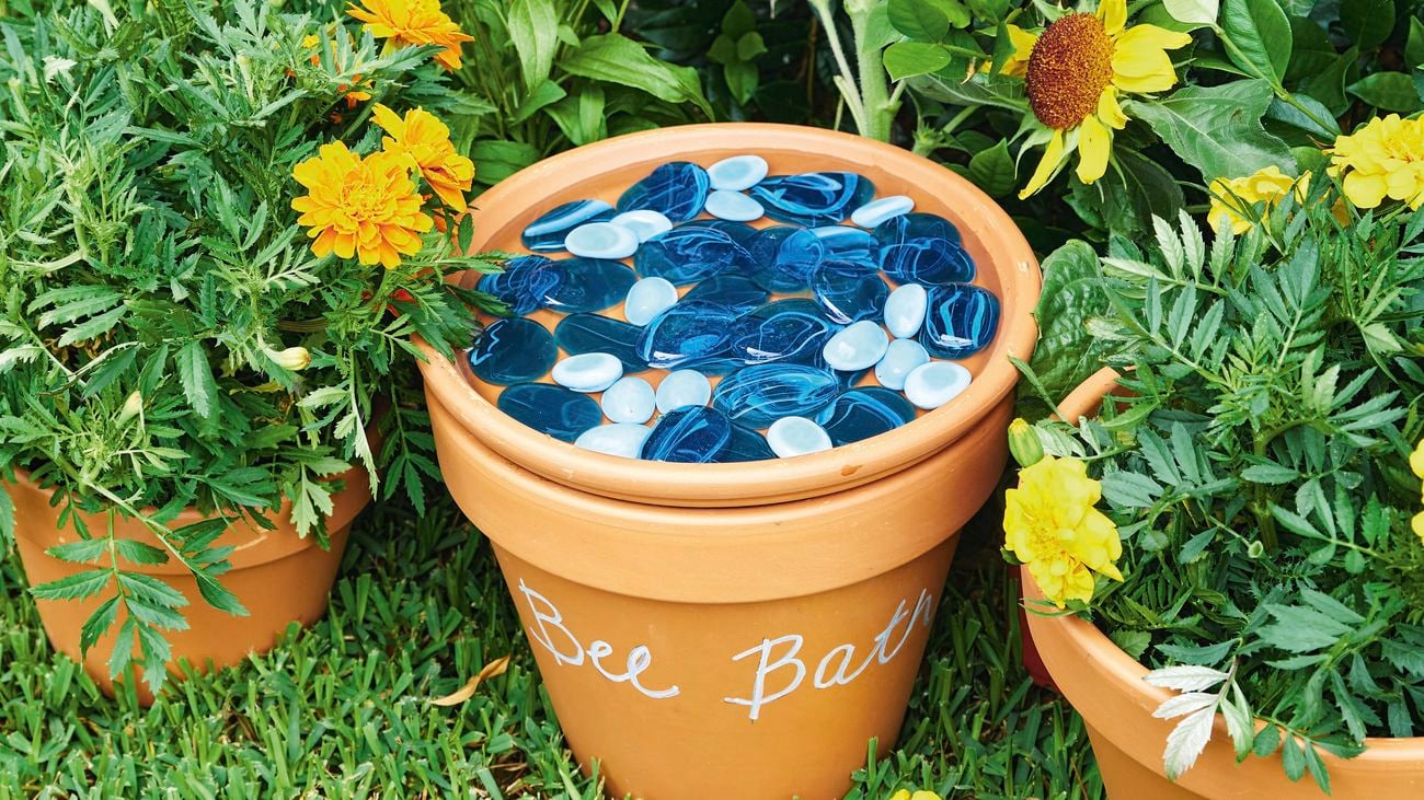 Terracotta pots with blue glas pebbles in one of them and flowers in the other 2.