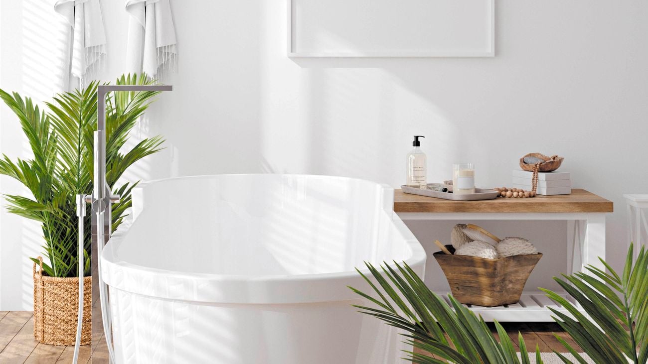 A white freestanding bath in a bathroom with timber floors.