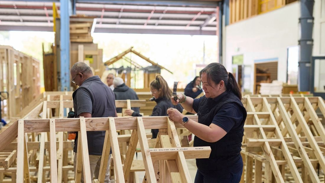 Several carpentry trade students work on frame and truss structures at Holmesglen Institute.