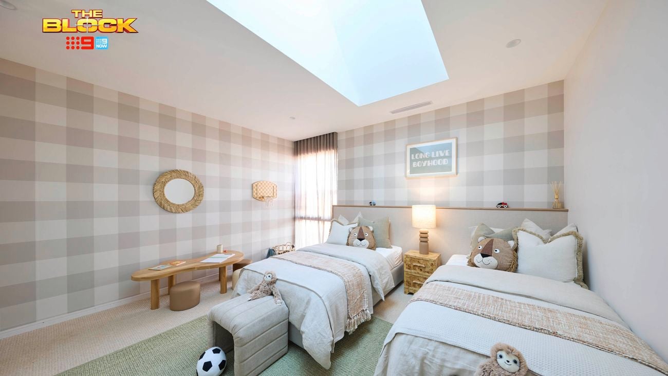 Sage and white bedroom with check wallpaper, two twin beds with white linen and a table and mirror on the wall.