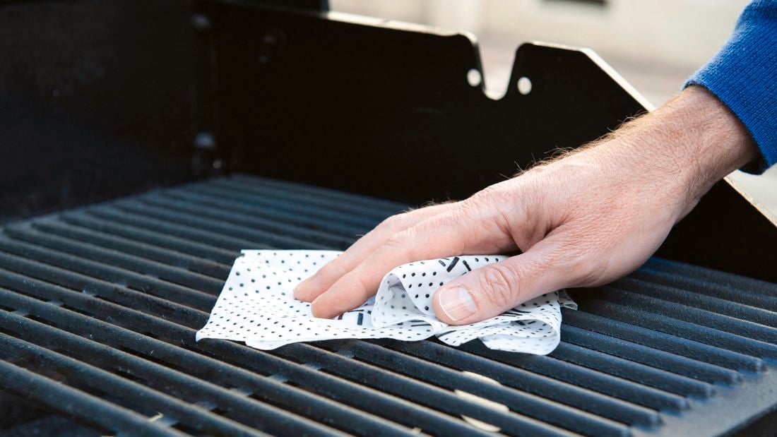 Close up of a cleaning cloth being used on a barbeque grill.