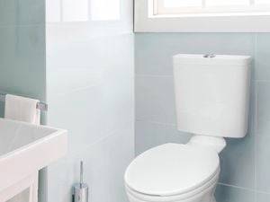 Spotless and clean toilet and sink in a modern bathroom.