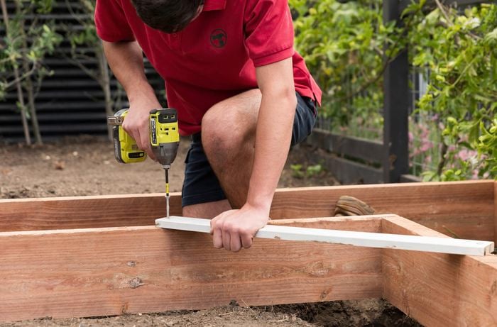 Attach a timber offcut to the corner using a Ryobi drill 