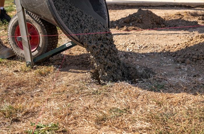 Concrete being poured into a stump hole