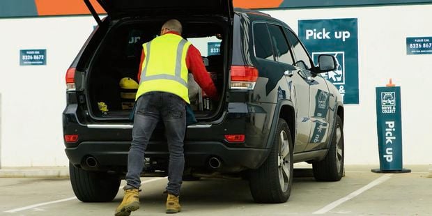 Bunnings TM loading items into a car out the front of a Bunnings store