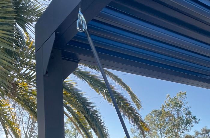 Person installing hand crank on the roof of a gazebo.