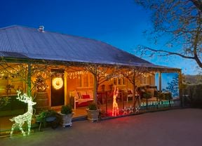Christmas lights and decorations at the front of an old style house at night