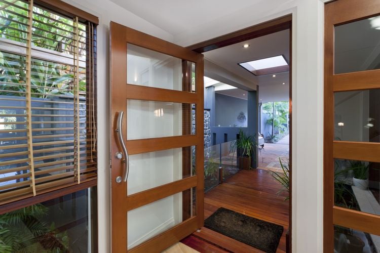 An ornate wooden and glass door with matching venetian blinds