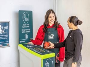 Bunnings team member helping a customer recycle their battery.