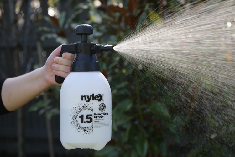 Person using pressurised water sprayer