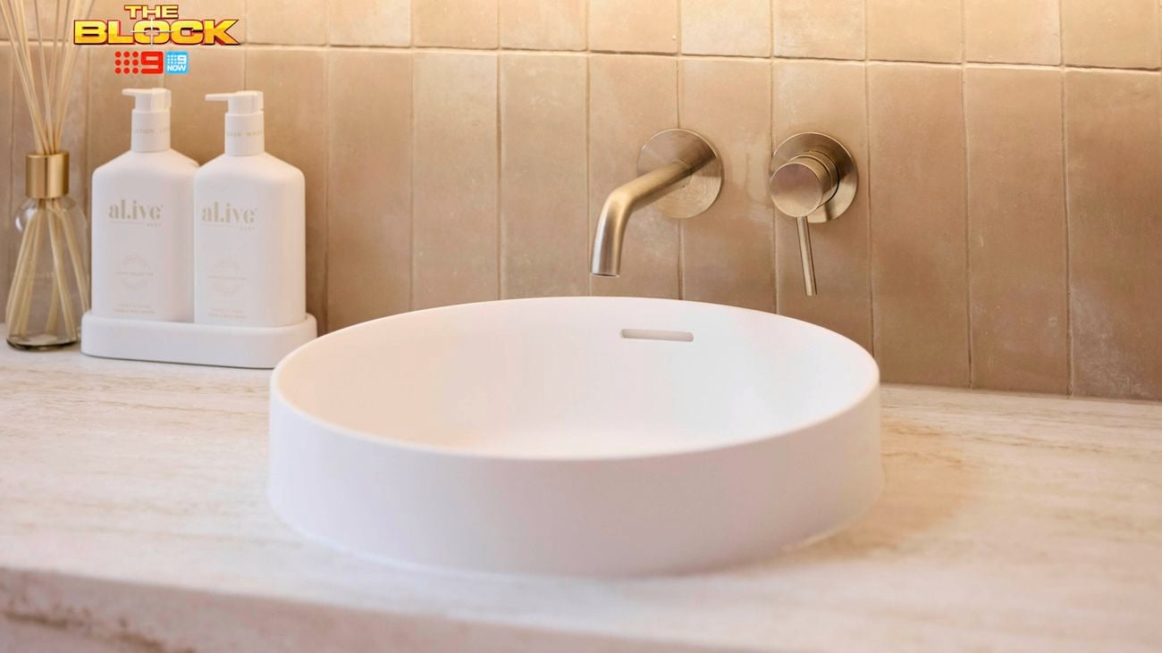 Round basin with gold tapware on a marble vanity