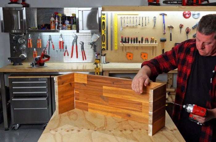 Man driving screw into timber to create ‘U’ shaped table top