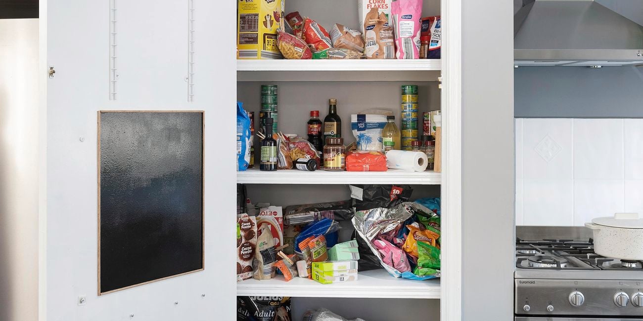 A disorganised pantry with nothing in order and food items piled on top of each other